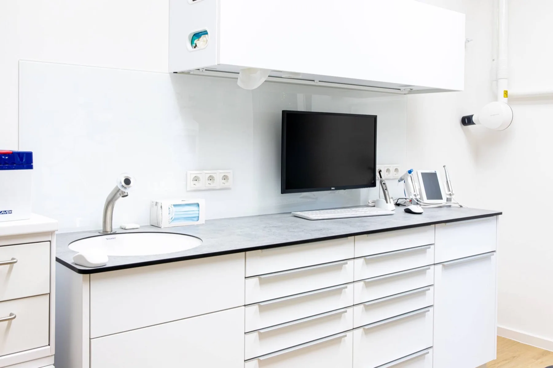 Behandlungszimmer der Zahnarztpraxis Kiel mit Monitor, Instrumenten und heller Arbeitsfläche
