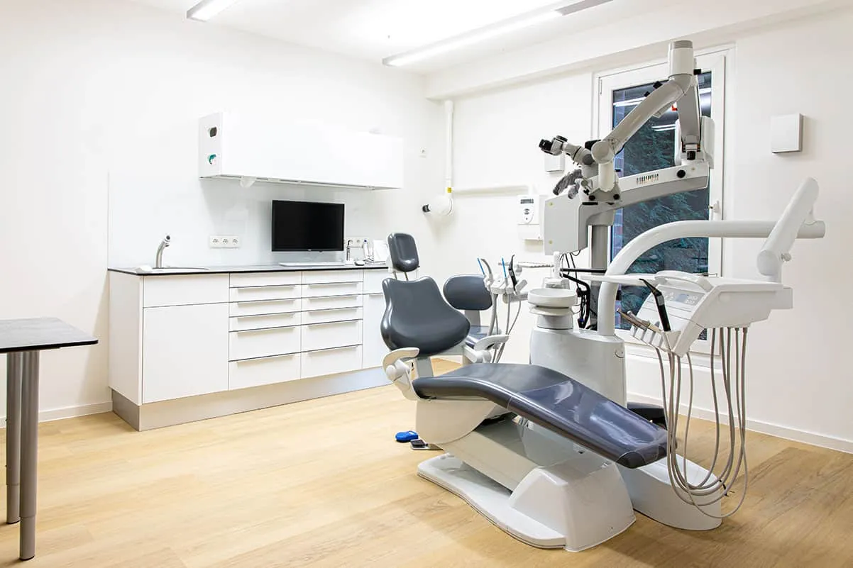 Behandlungszimmer für Endodontie in Kiel-Düsternbrook mit Behandlungsstuhl und OP-Mikroskop